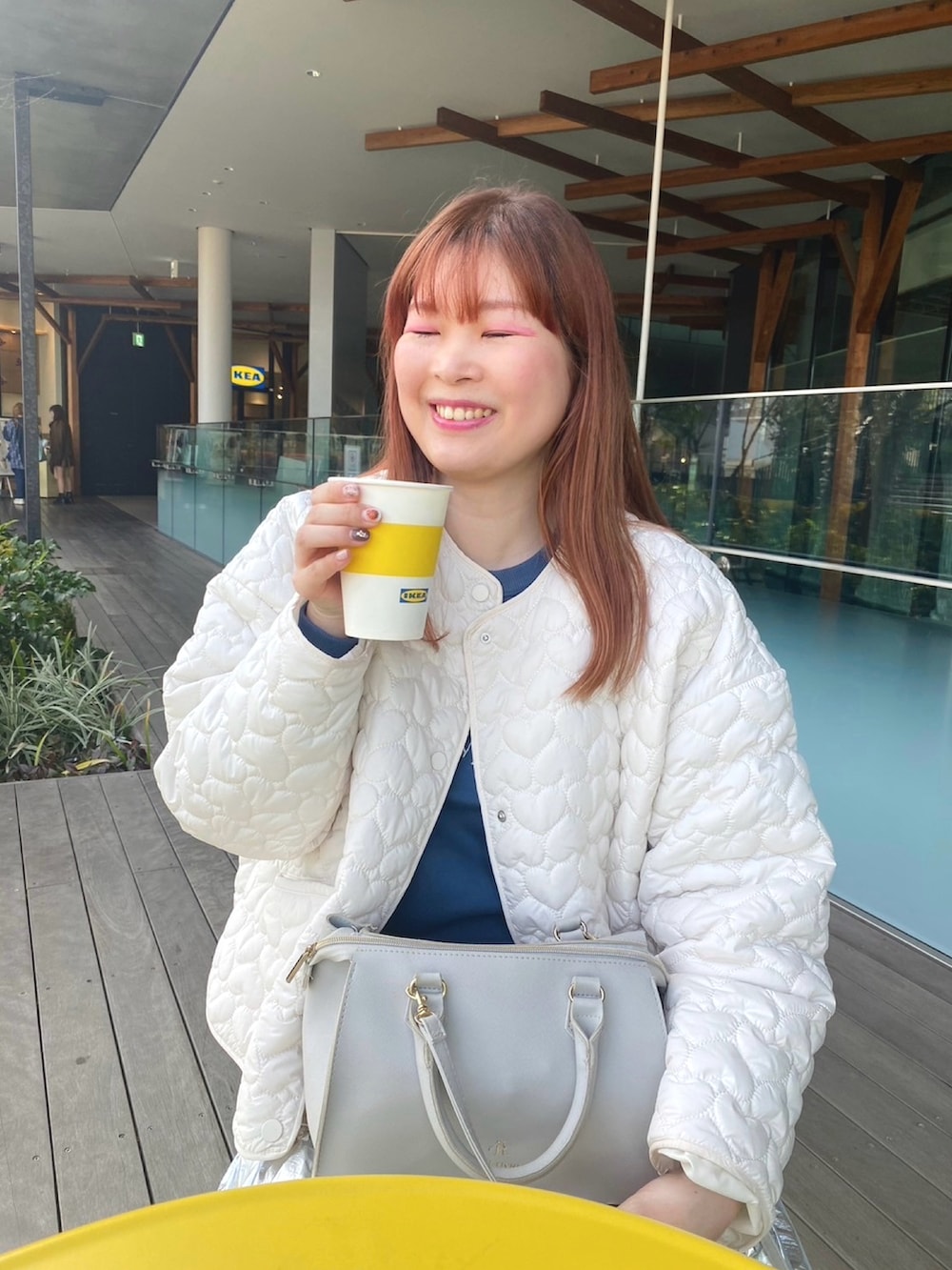 ブルー系のスウェット、シルバー系のスカート、グレー系のショルダーバッグを着用したレディースの冬コーディネートの2枚目の写真