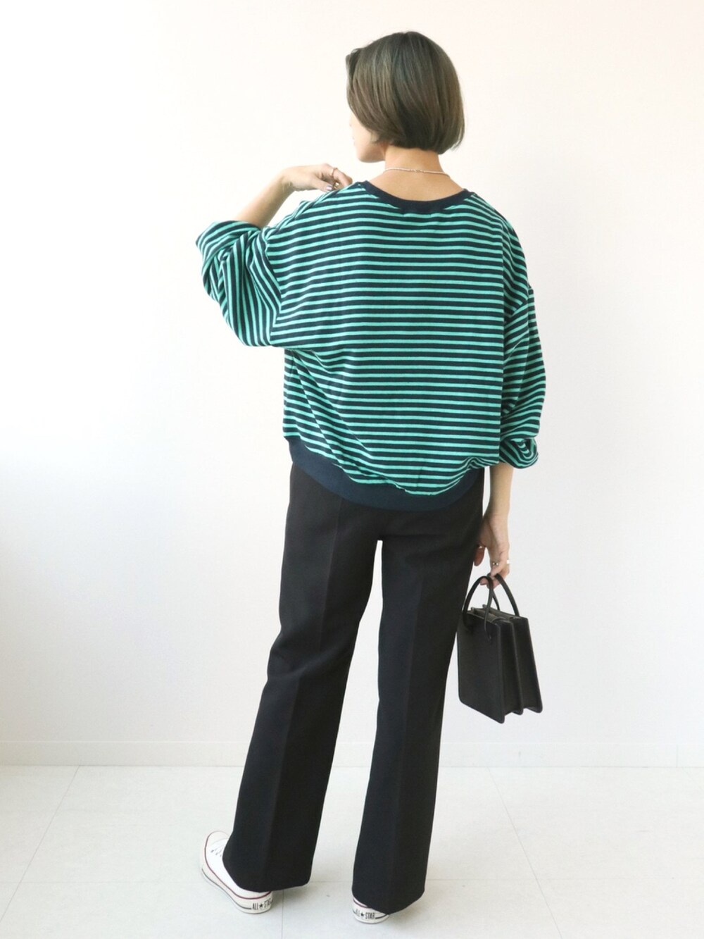 ブルー系のTシャツ/カットソー、ブラック系のスラックスを着用したレディースの秋コーディネートの2枚目の写真