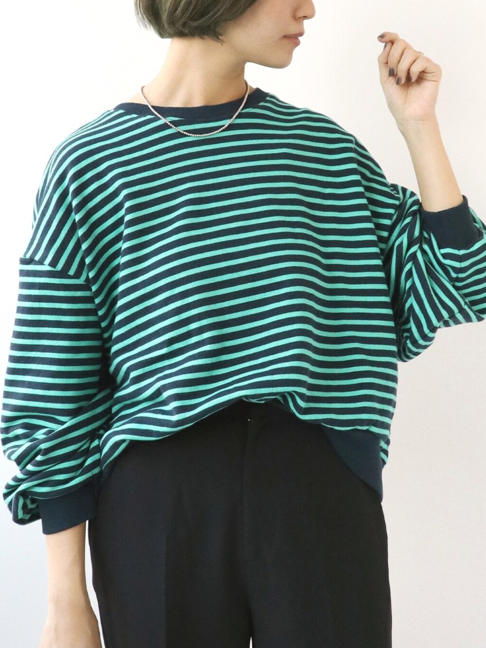 ブルー系のTシャツ/カットソー、ブラック系のスラックスを着用したレディースの秋コーディネートの5枚目の写真