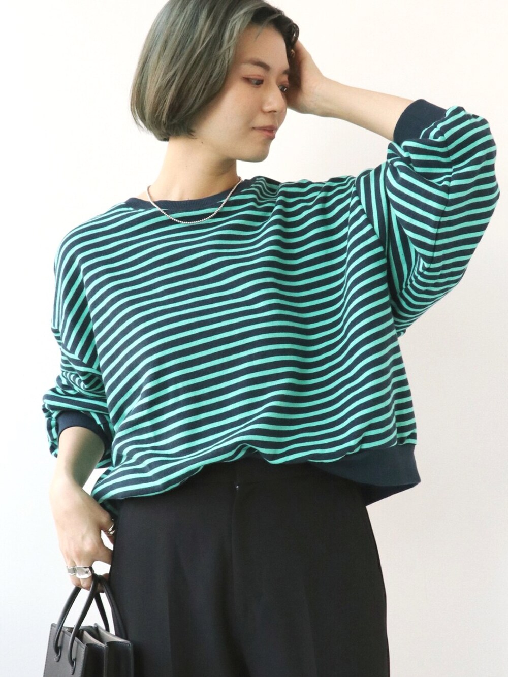 ブルー系のTシャツ/カットソー、ブラック系のスラックスを着用したレディースの秋コーディネートの4枚目の写真