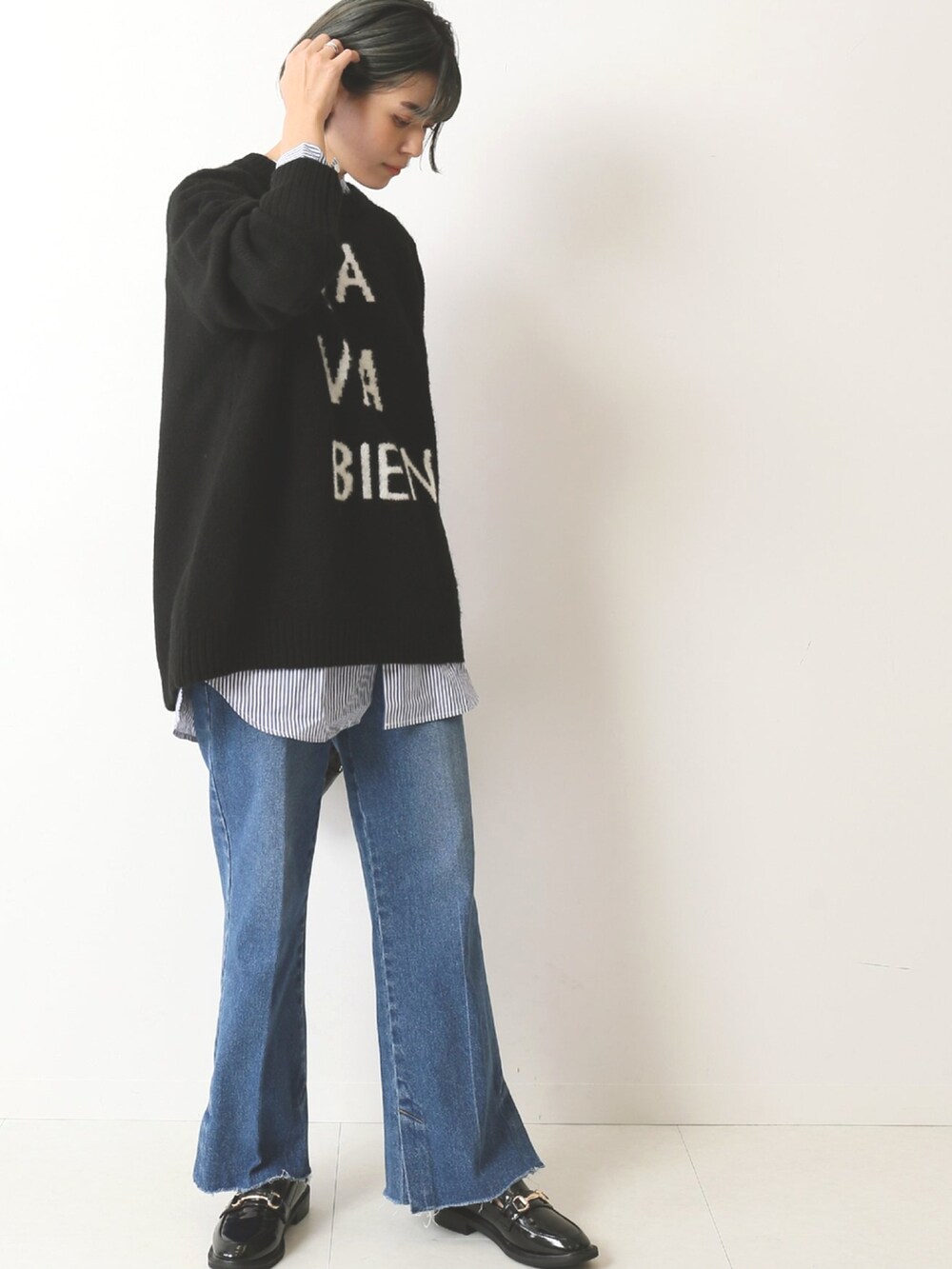 ブラック系のニット/セーター、ブルー系のデニムパンツを着用したレディースの秋コーディネートの3枚目の写真