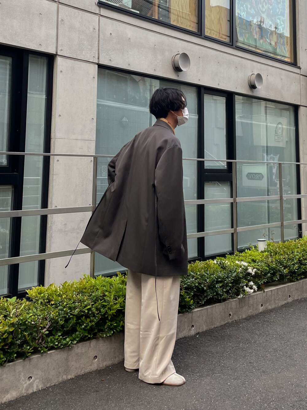 ホワイト系のスラックス、ホワイト系のブーツ、ホワイト系のTシャツ/カットソーを着用したメンズの春コーディネートの3枚目の写真
