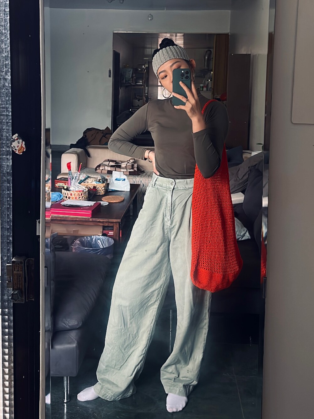 グリーン系のチノパンツ、ブルー系のシャツ/ブラウス、オレンジ系のショルダーバッグを着用したレディースの春コーディネートの2枚目の写真