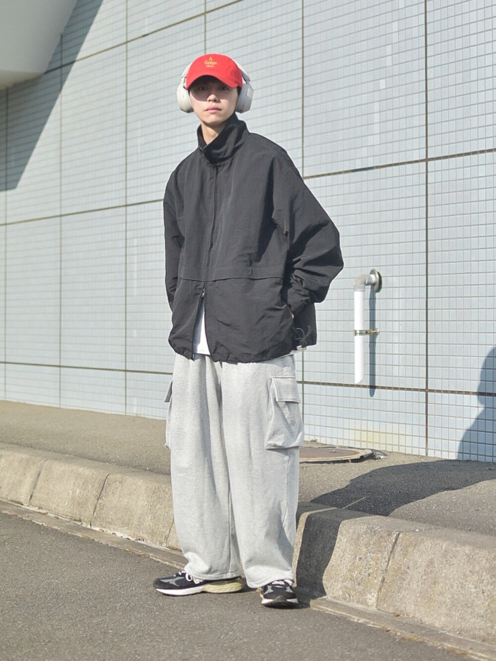 ブラック系のナイロンジャケット、グレー系のTシャツ/カットソー、グレー系のスウェットパンツを着用したメンズの春コーディネートの3枚目の写真