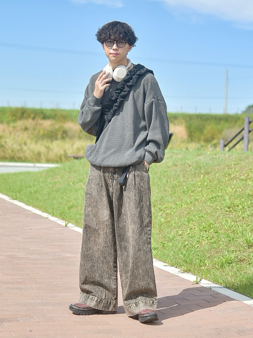 グレー系のTシャツ/カットソー、ブラウン系のデニムパンツ、ブラウン系のスニーカーを着用したメンズの秋コーディネートの2枚目の写真