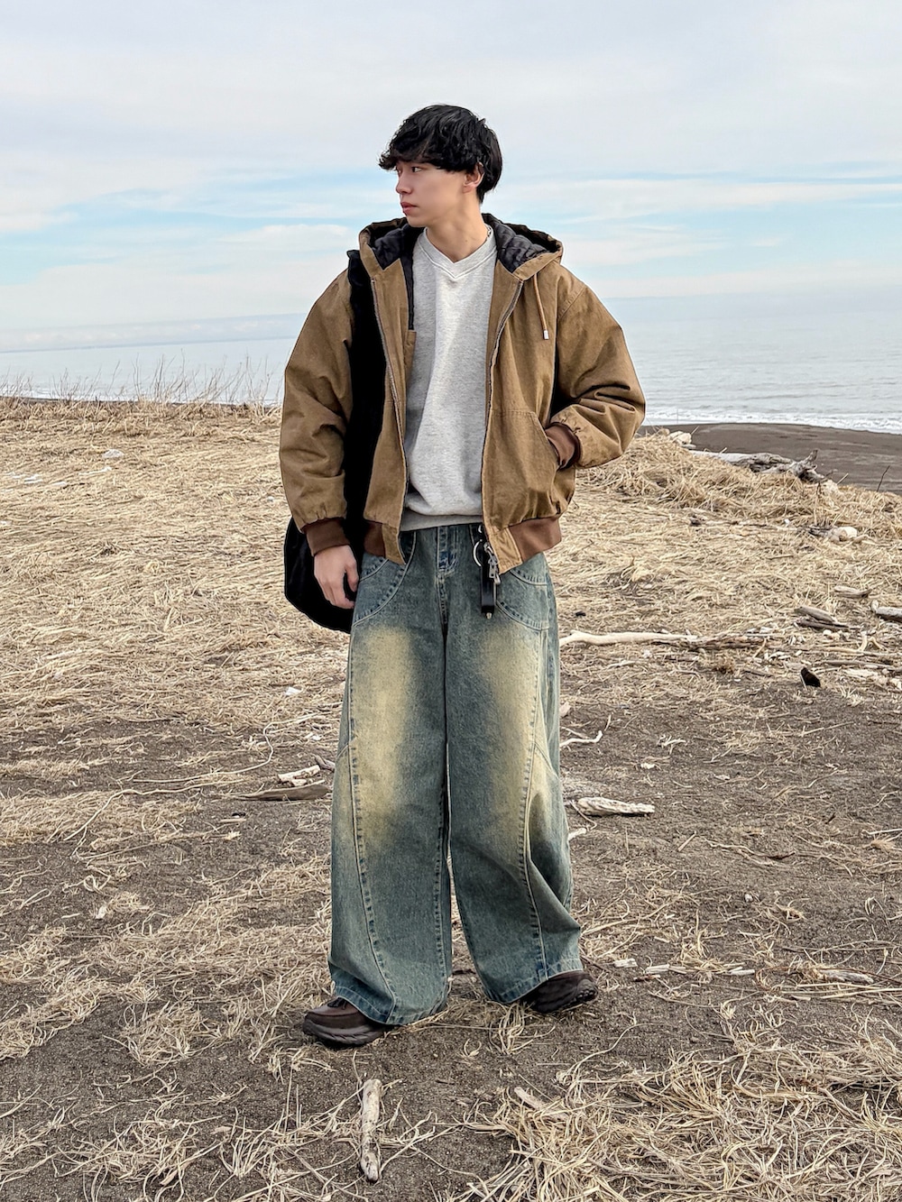 ブラウン系のその他アウター、ブルー系のデニムパンツ、グレー系のスウェットを着用したメンズの冬コーディネートの3枚目の写真