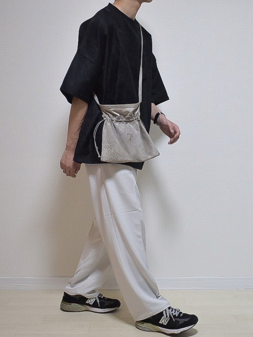 ブラック系のTシャツ/カットソー、グレー系のスラックス、ブラック系のシューズを着用したメンズの夏コーディネートの3枚目の写真