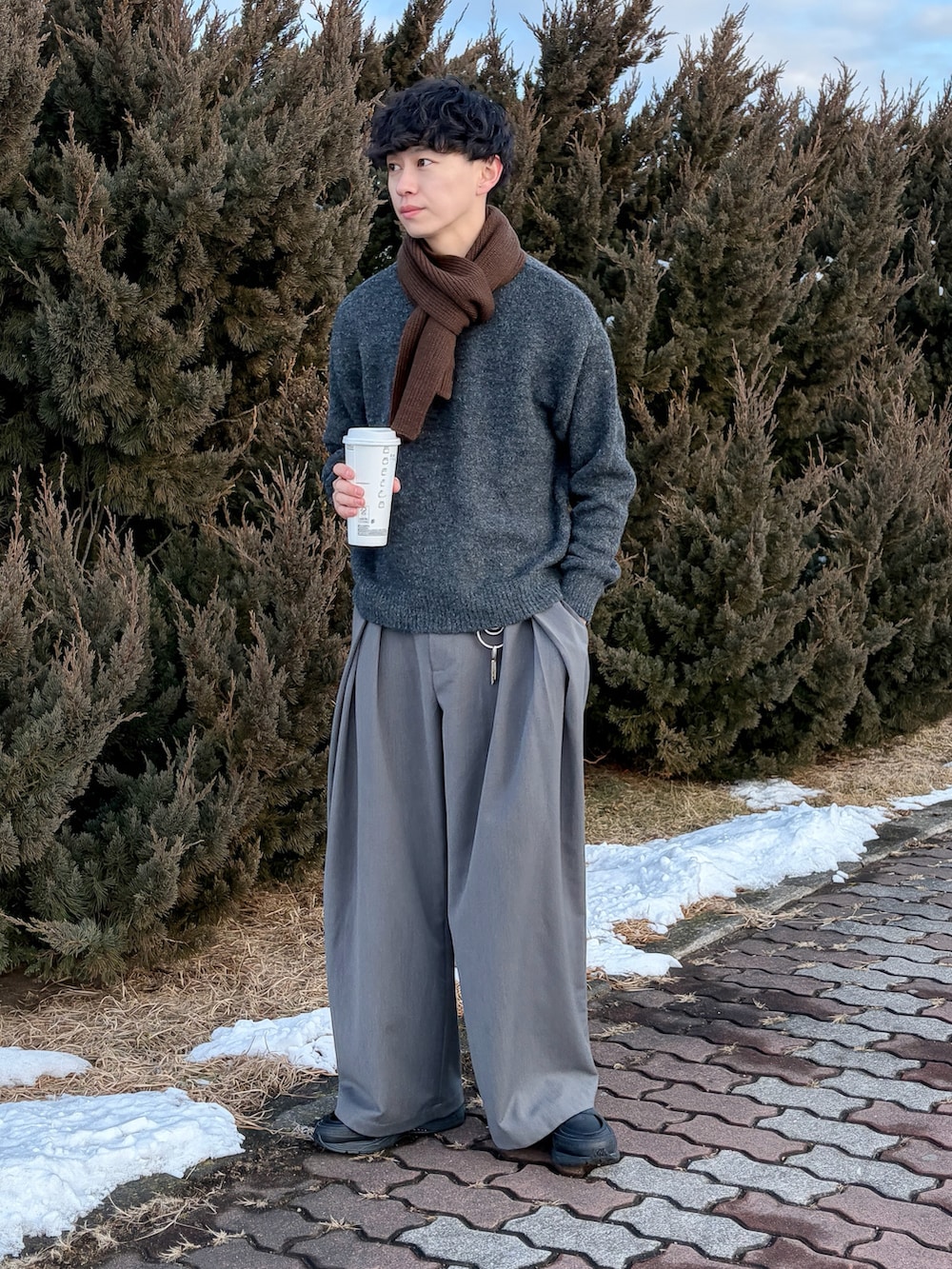 ブラウン系のニット/セーター、グレー系のスラックス、ブラック系のシューズを着用したメンズの冬コーディネートの3枚目の写真