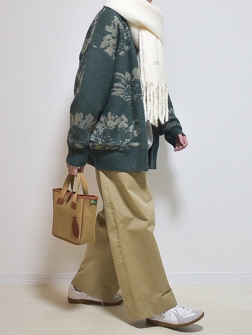 グリーン系のカーディガン/ボレロ、ホワイト系のマフラーを着用したメンズの冬コーディネートの3枚目の写真