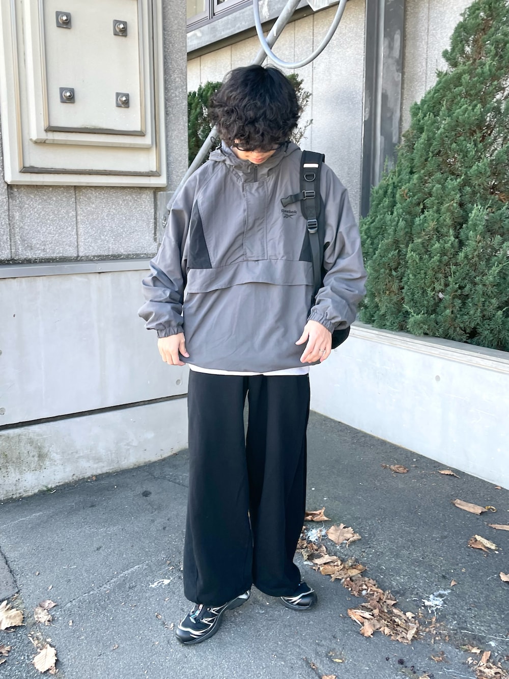 グレー系のナイロンジャケット、グレー系のスウェット、ブラック系のスウェットパンツを着用したメンズの秋コーディネートの3枚目の写真