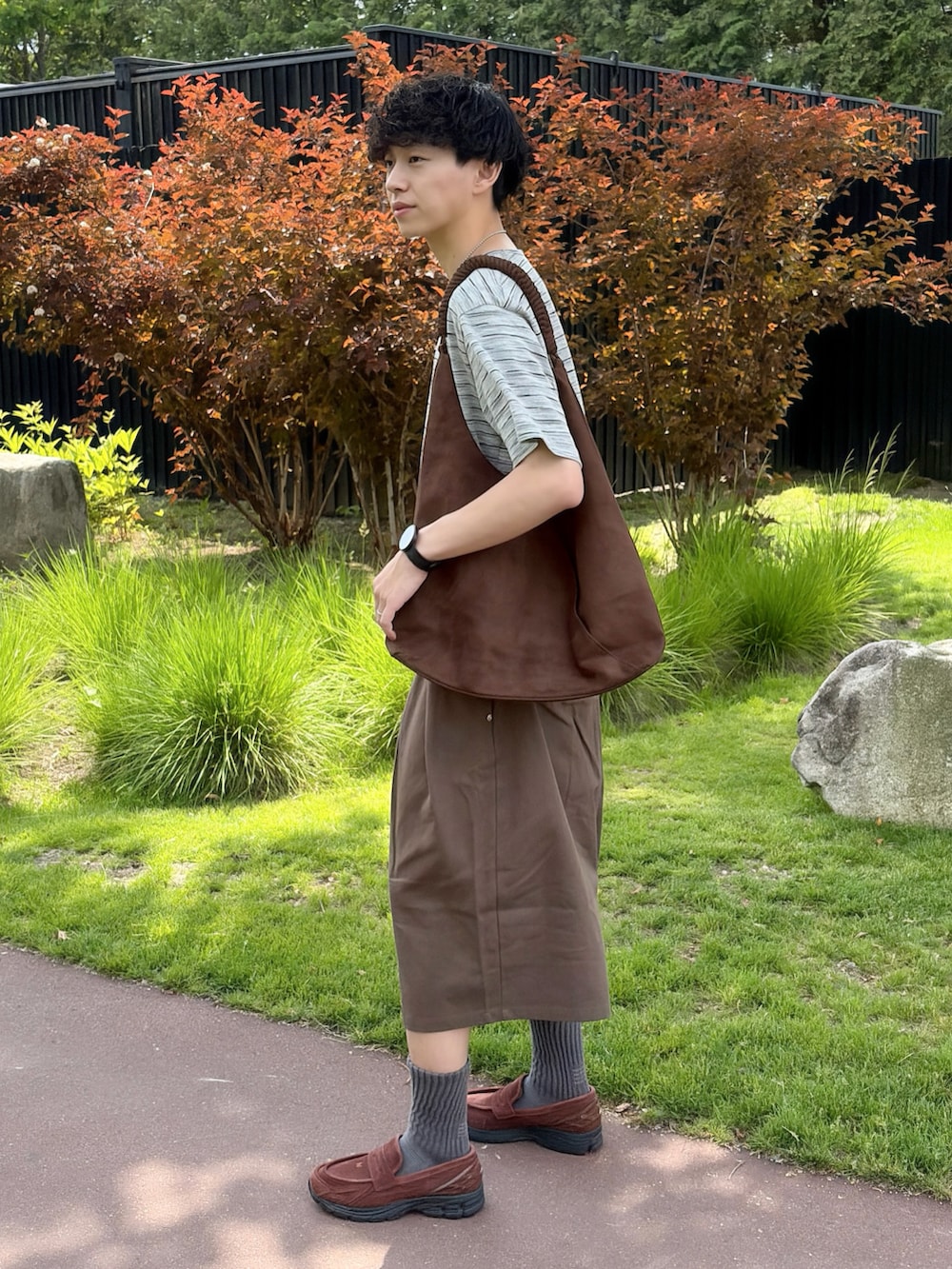 グレー系のTシャツ/カットソー、グリーン系のその他パンツ、ブラウン系のスニーカーを着用したメンズの夏コーディネートの3枚目の写真