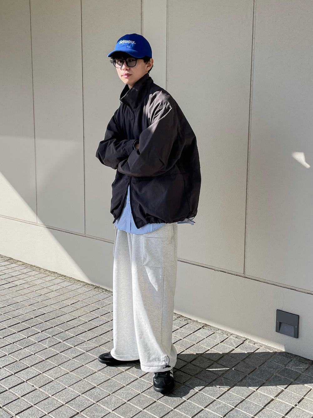 グレー系のナイロンジャケット、ブルー系のシャツ/ブラウス、ホワイト系のパンツを着用したメンズの冬コーディネートの4枚目の写真