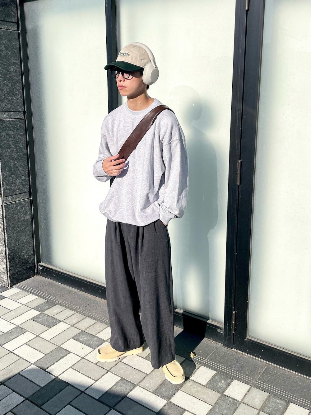 グレー系のスウェット、グレー系のスラックス、ベージュ系のモカシン/デッキシューズを着用したメンズの秋コーディネートの5枚目の写真