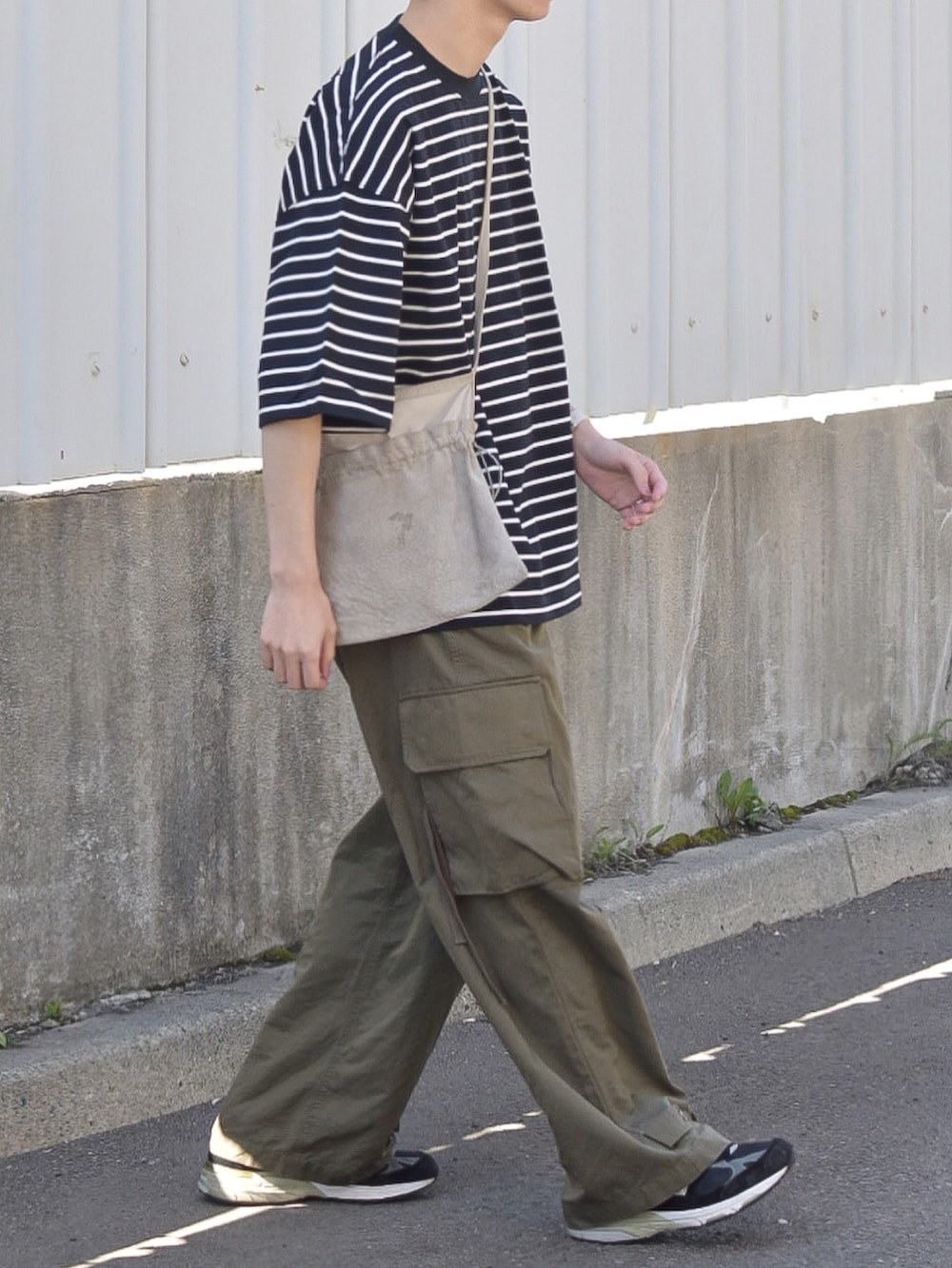 ブラック系のTシャツ/カットソー、グリーン系のカーゴパンツ、ブラック系のシューズを着用したメンズの夏コーディネートの3枚目の写真