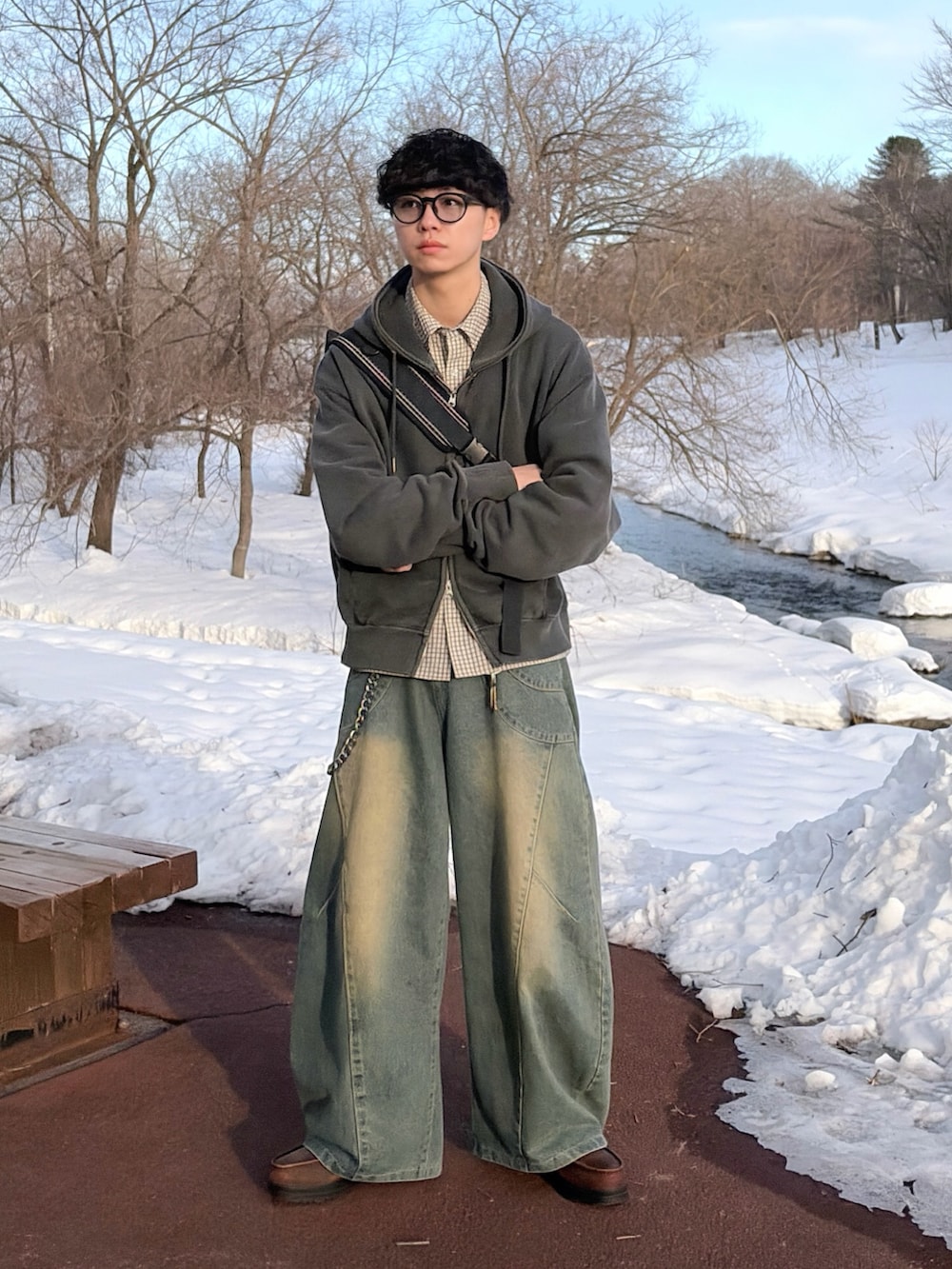 ブルー系のデニムパンツ、グレー系のパーカー、ブラック系のボディバッグ/ウエストポーチを着用したメンズの冬コーディネートの2枚目の写真