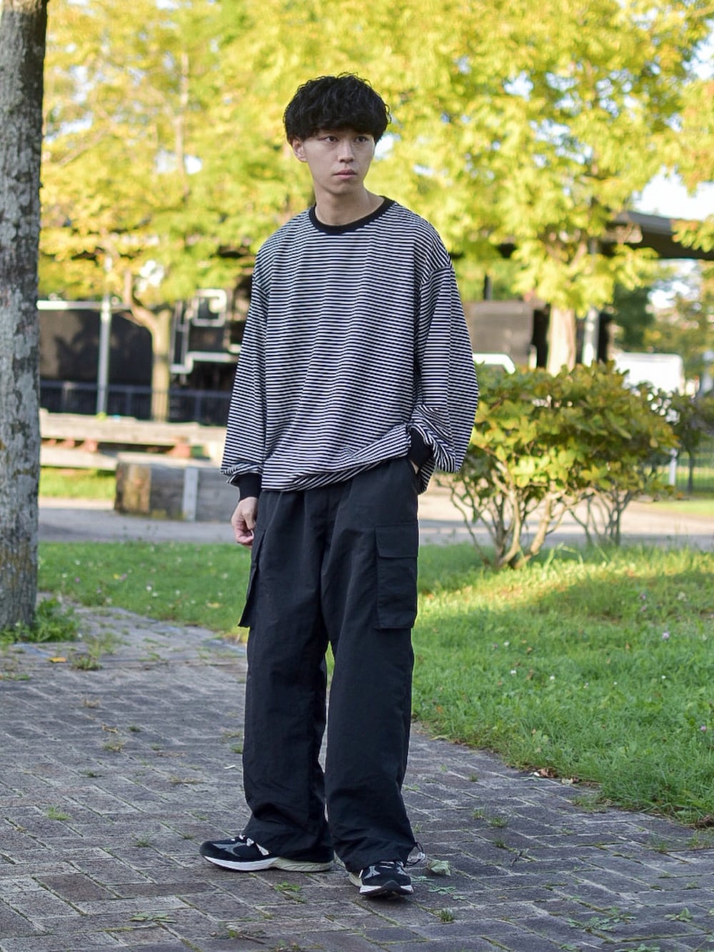 ブラック系のシューズ、ブラック系のカーゴパンツ、ブラック系のTシャツ/カットソーを着用したメンズの秋コーディネートの2枚目の写真