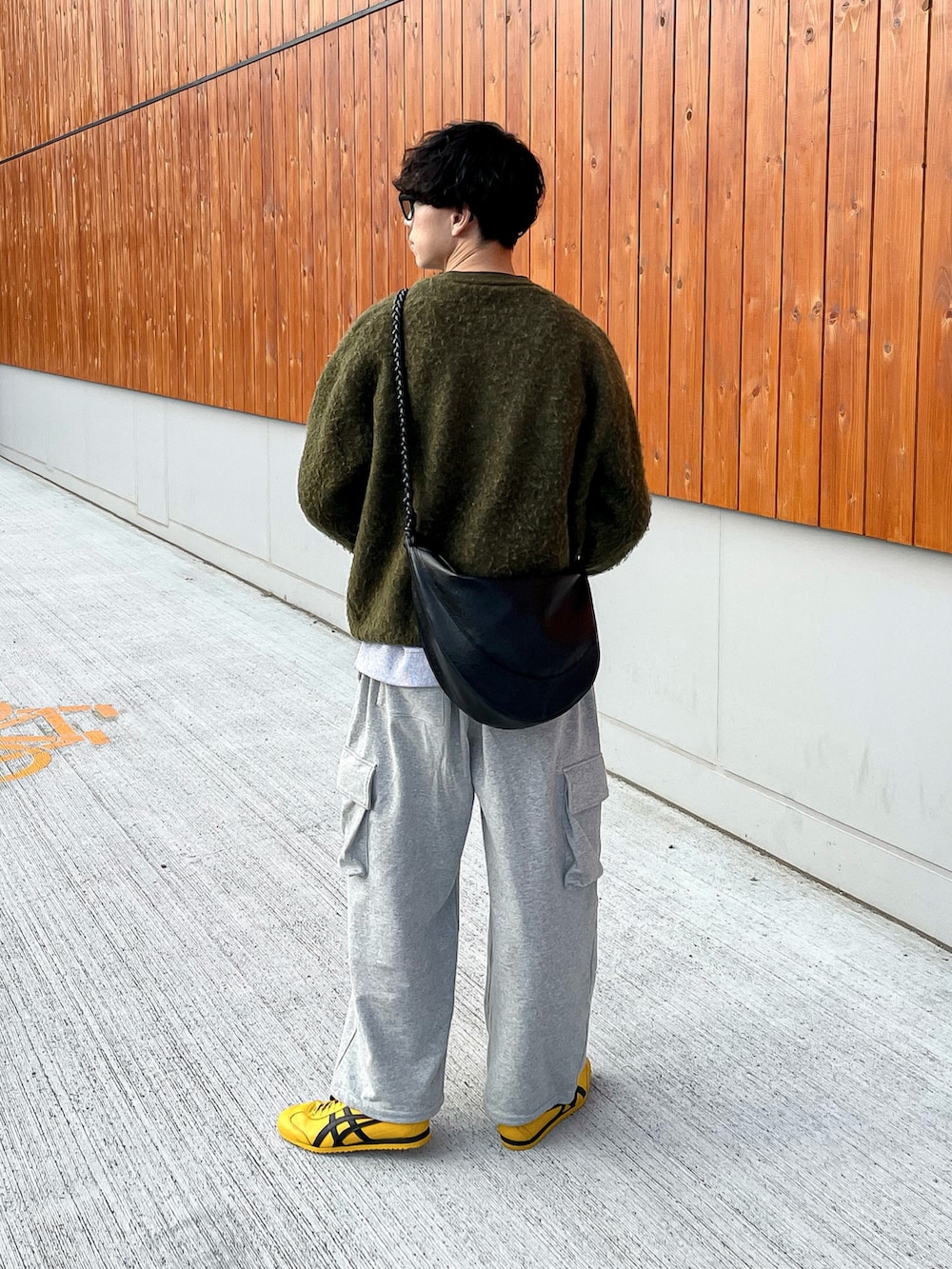 グレー系のスウェットパンツ、グレー系のスウェット、イエロー系のスニーカーを着用したメンズの秋コーディネートの3枚目の写真
