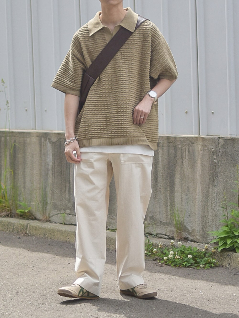 グリーン系のポロシャツ、ホワイト系のデニムパンツ、ベージュ系のスニーカーを着用したメンズの夏コーディネートの3枚目の写真