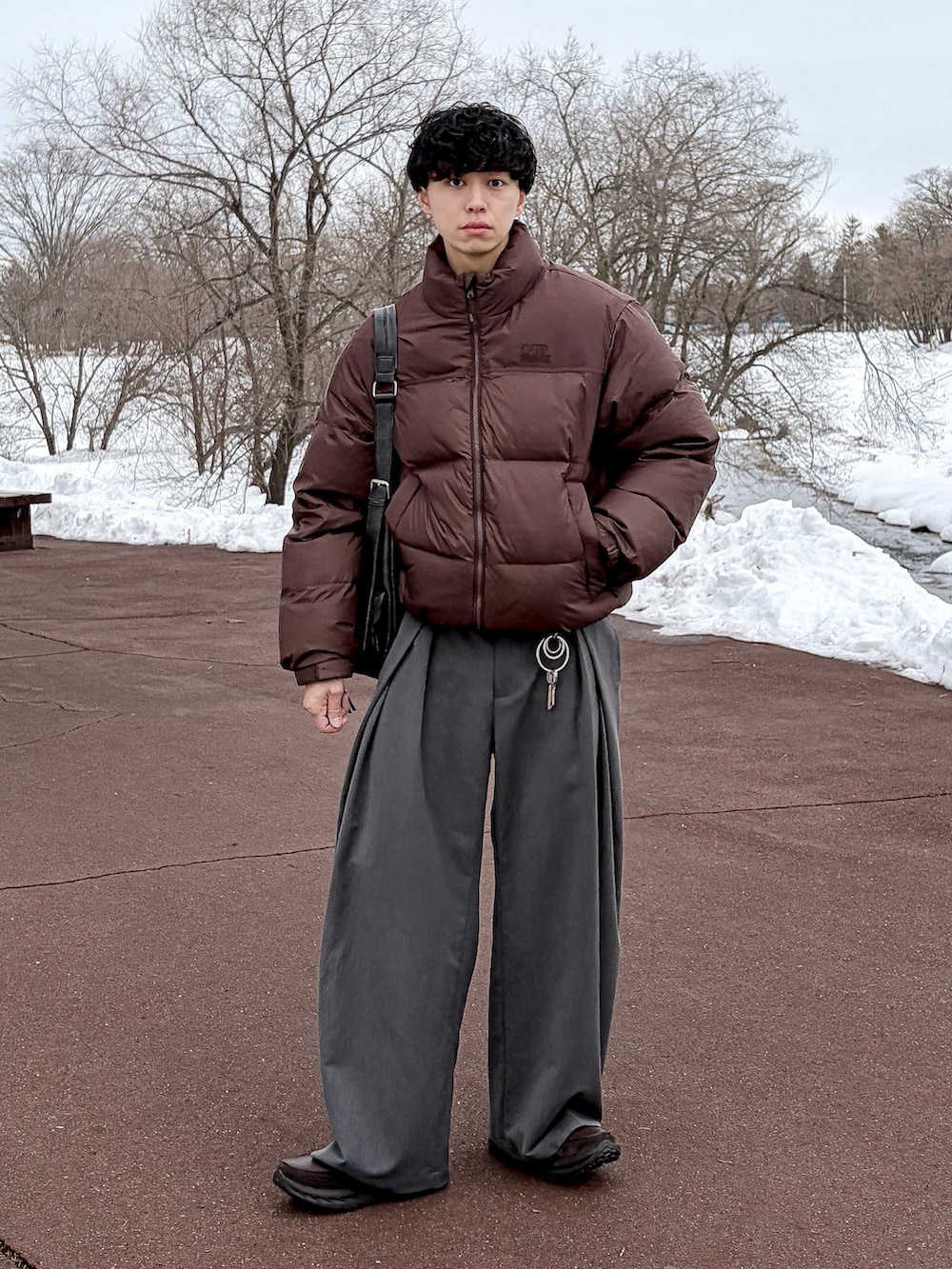 グレー系のスウェット、ブラウン系のダウンジャケット/コート、グレー系のスラックスを着用したメンズの冬コーディネートの4枚目の写真