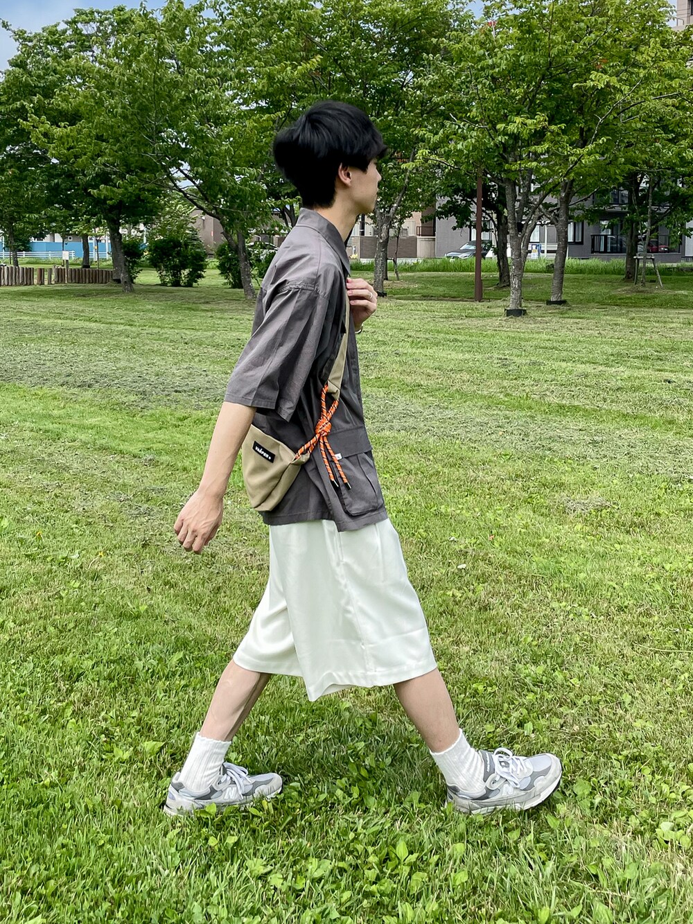 グレー系のシャツ/ブラウス、ホワイト系のその他パンツ、グレー系のスニーカーを着用したメンズの夏コーディネートの5枚目の写真