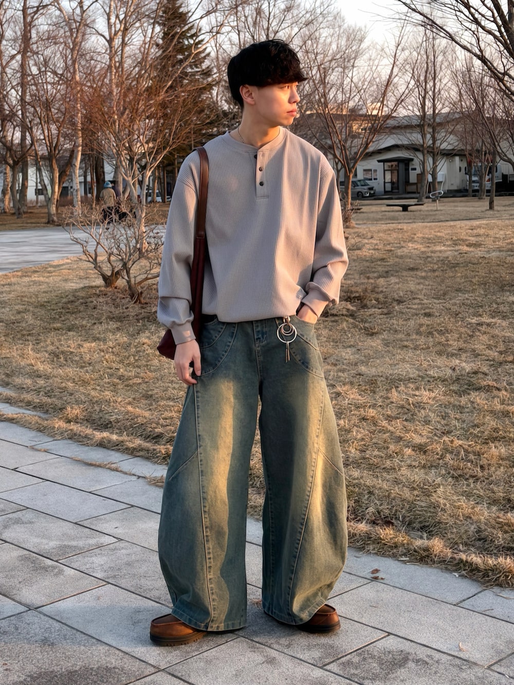 グレー系のTシャツ/カットソー、ブルー系のデニムパンツ、ブラウン系のショルダーバッグを着用したメンズの春コーディネートの3枚目の写真