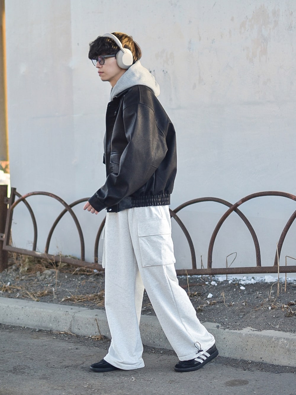 ブラック系のブルゾン、ブラック系のスニーカー、グレー系のパーカーを着用したメンズの冬コーディネートの4枚目の写真