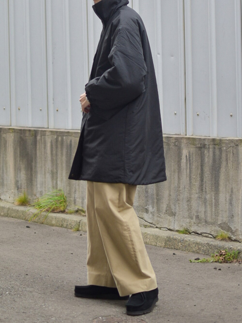 グレー系のニット/セーター、ベージュ系のその他パンツ、ブラック系のキャップを着用したメンズの秋コーディネートの4枚目の写真