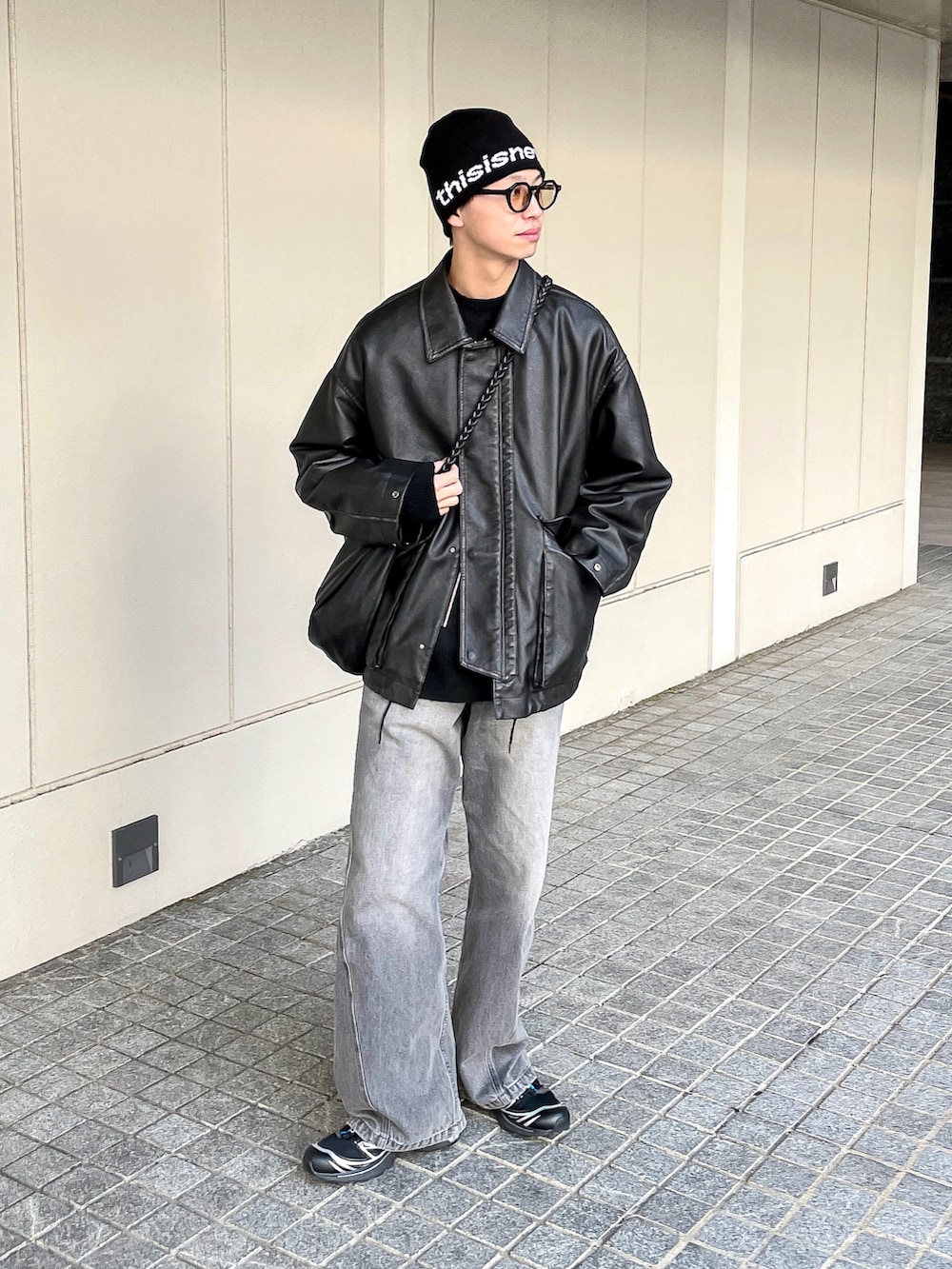 ブラック系のブルゾン、グレー系のニット/セーター、グレー系のデニムパンツを着用したメンズの冬コーディネートの2枚目の写真