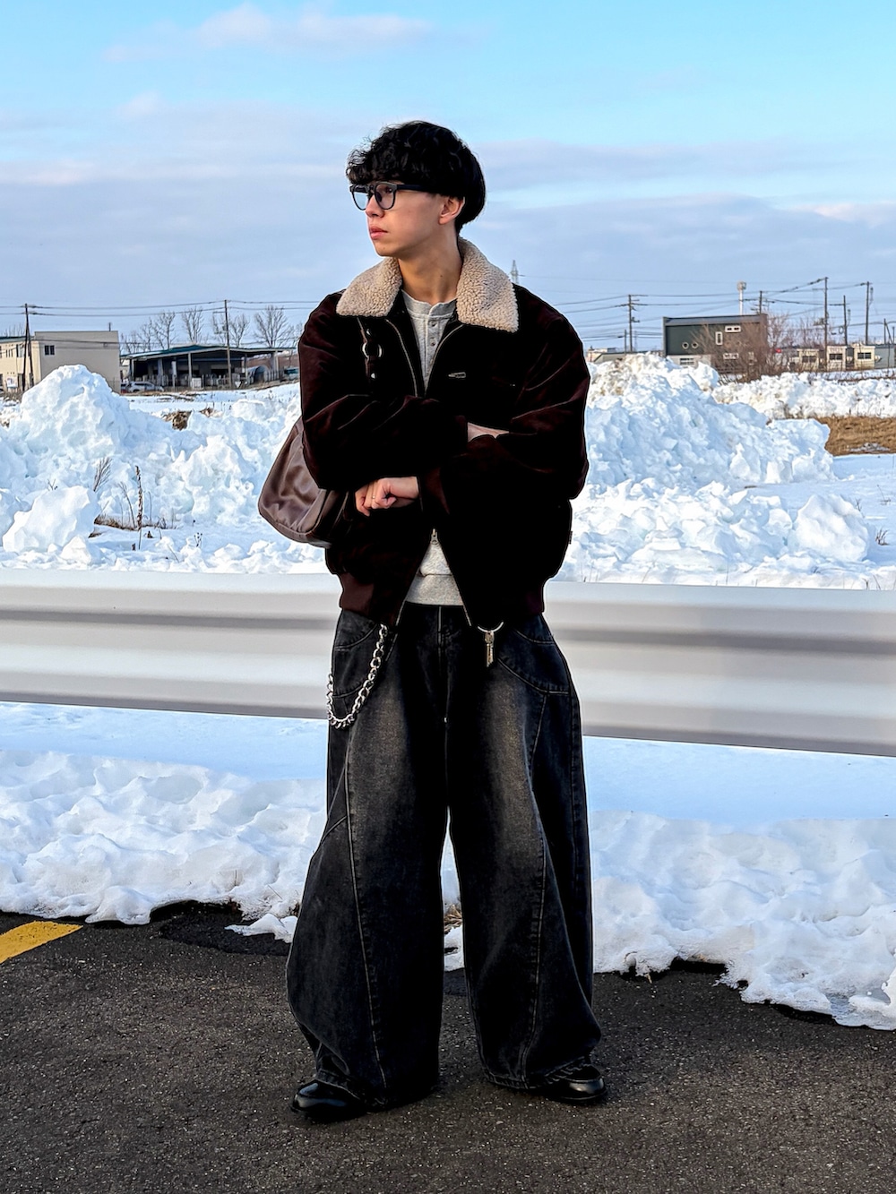 ブラウン系のブルゾン、グレー系のスウェット、ブラック系のデニムパンツを着用したメンズの冬コーディネートの3枚目の写真