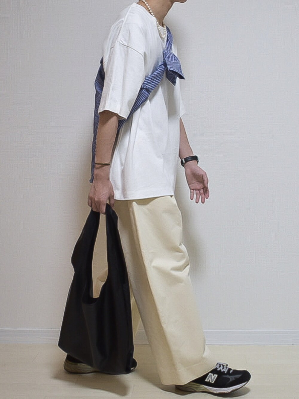ホワイト系のTシャツ/カットソー、ホワイト系のチノパンツ、ブラック系のシューズを着用したメンズの夏コーディネートの2枚目の写真