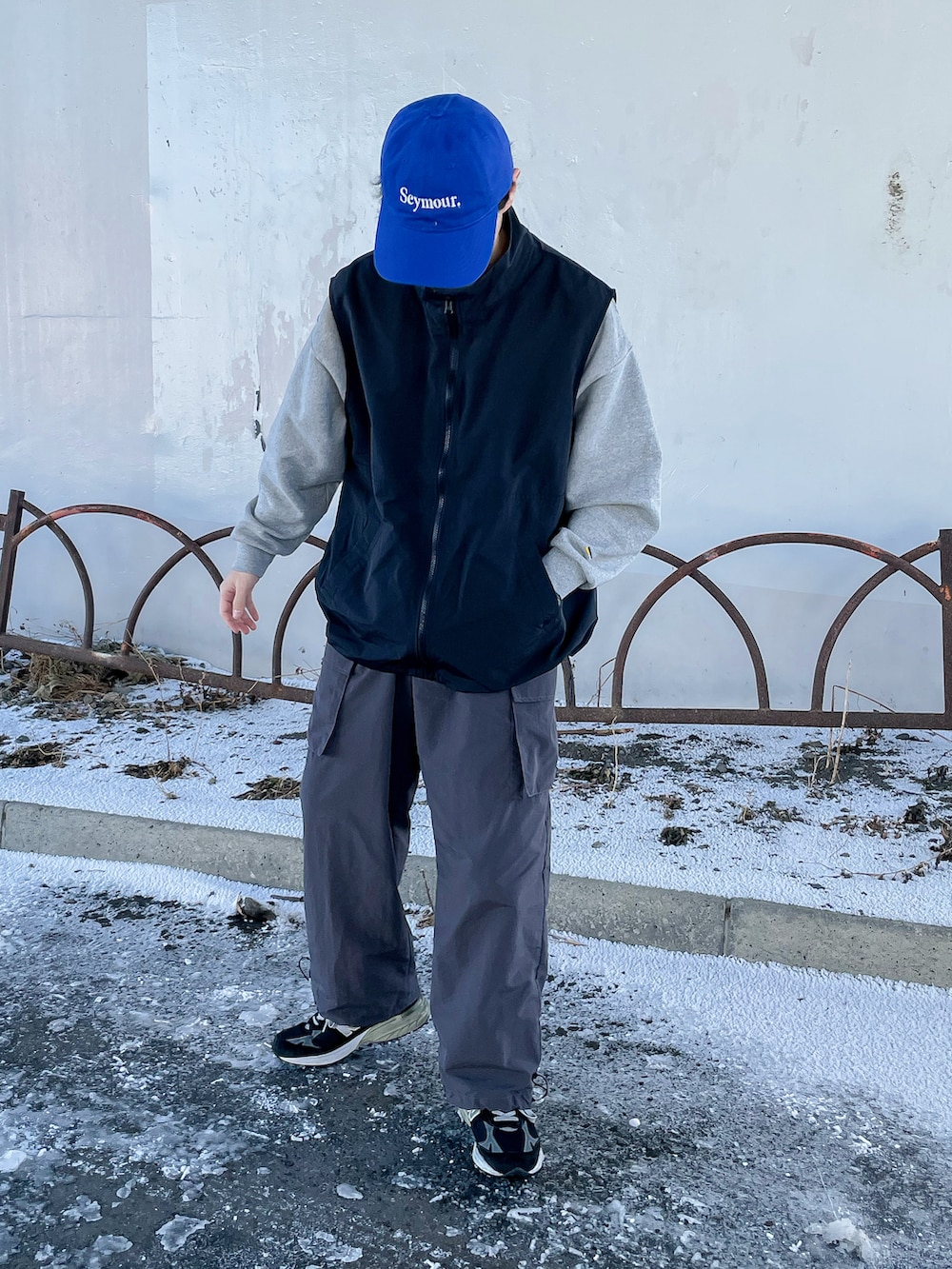 グレー系のカーゴパンツ、ブラック系のベスト、ブラック系のシューズを着用したメンズの冬コーディネートの5枚目の写真