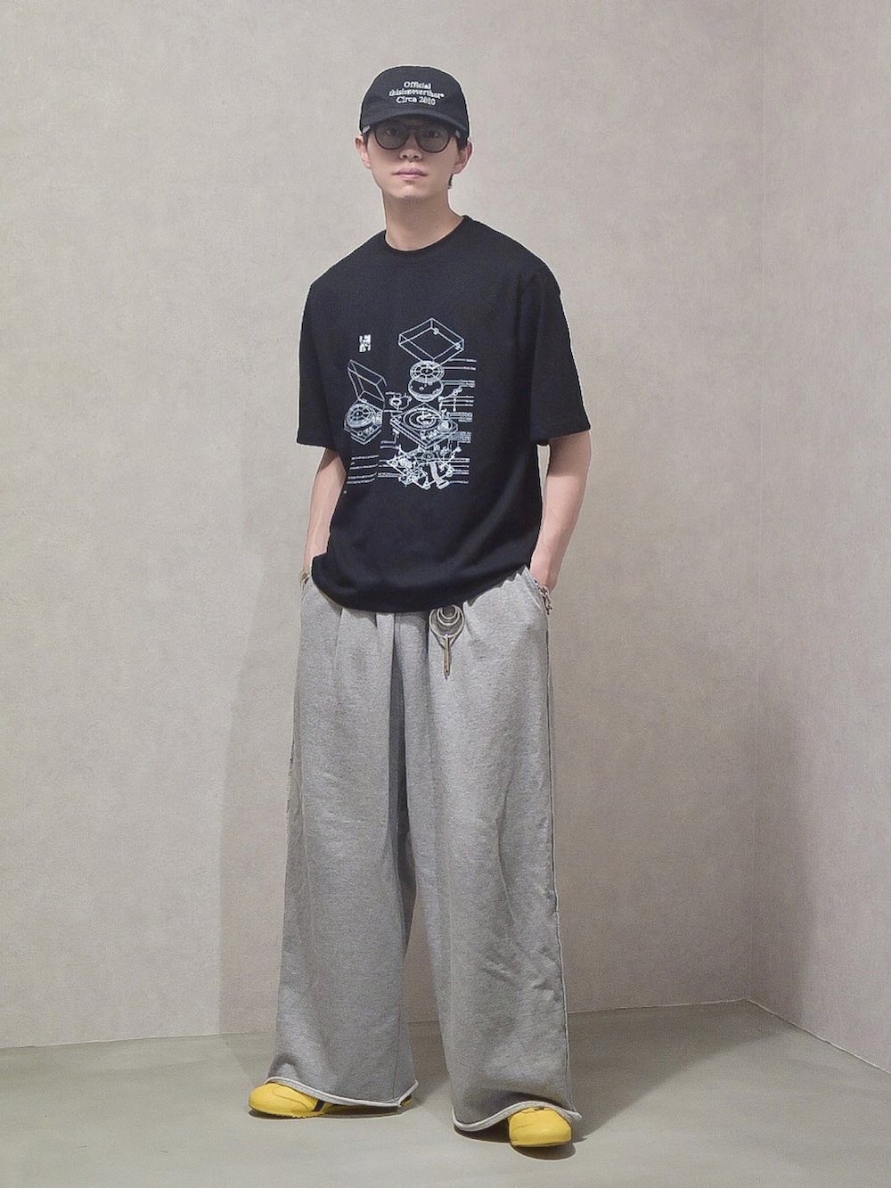 ブラック系のTシャツ/カットソー、グレー系のスウェットパンツ、イエロー系のスニーカーを着用したメンズの夏コーディネートの2枚目の写真