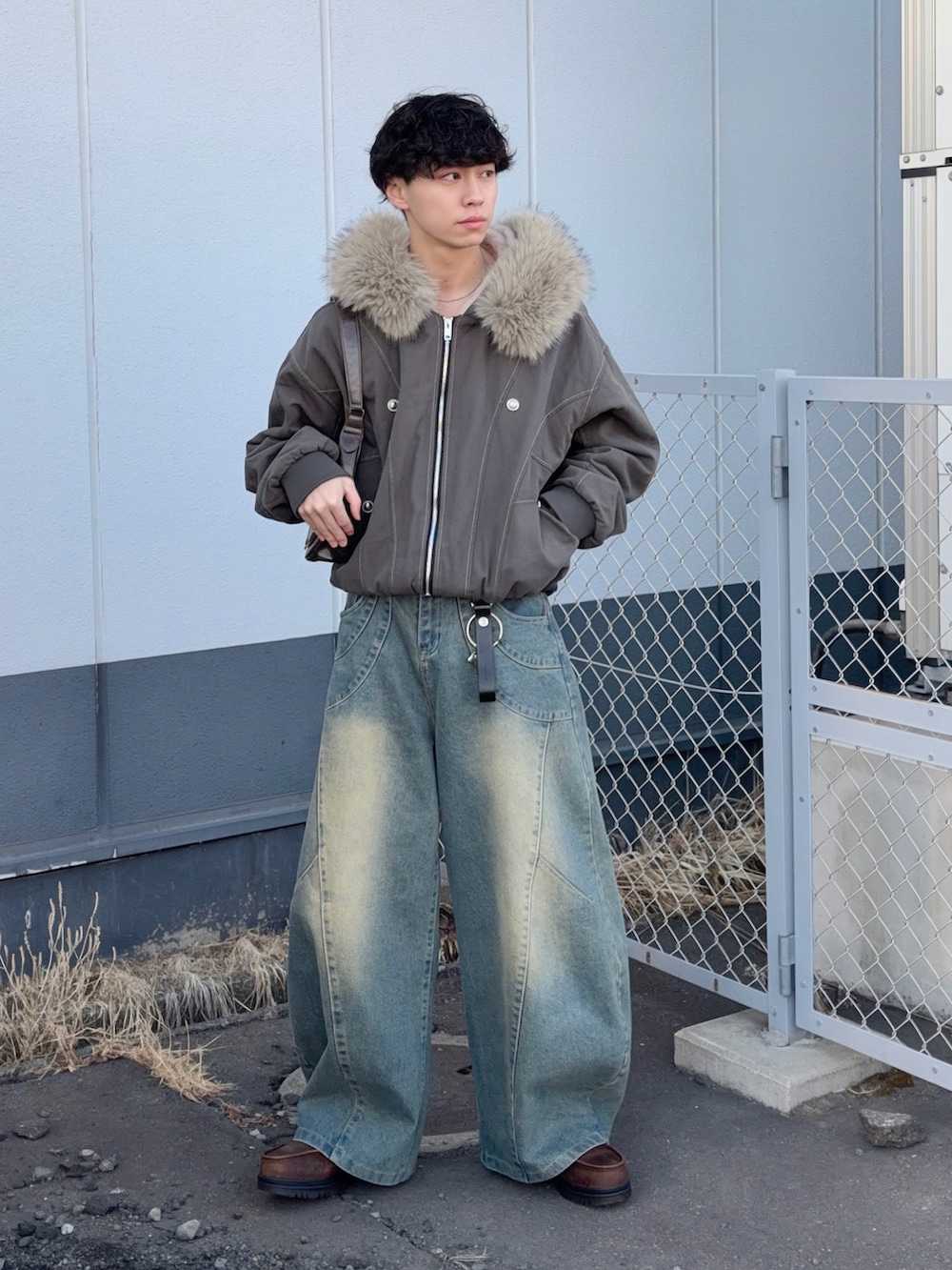 ブラウン系のブルゾン、ブルー系のデニムパンツ、ブラウン系のブーツを着用したメンズの冬コーディネートの3枚目の写真