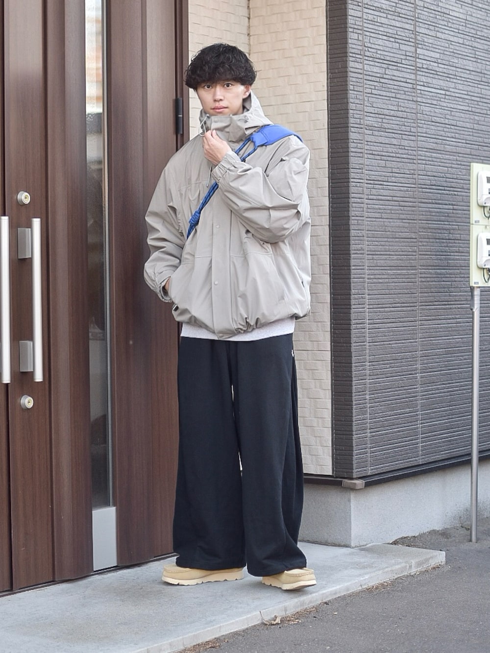 ブラック系のスウェットパンツ、ベージュ系のマウンテンパーカー、グレー系のスウェットを着用したメンズの秋コーディネートの2枚目の写真