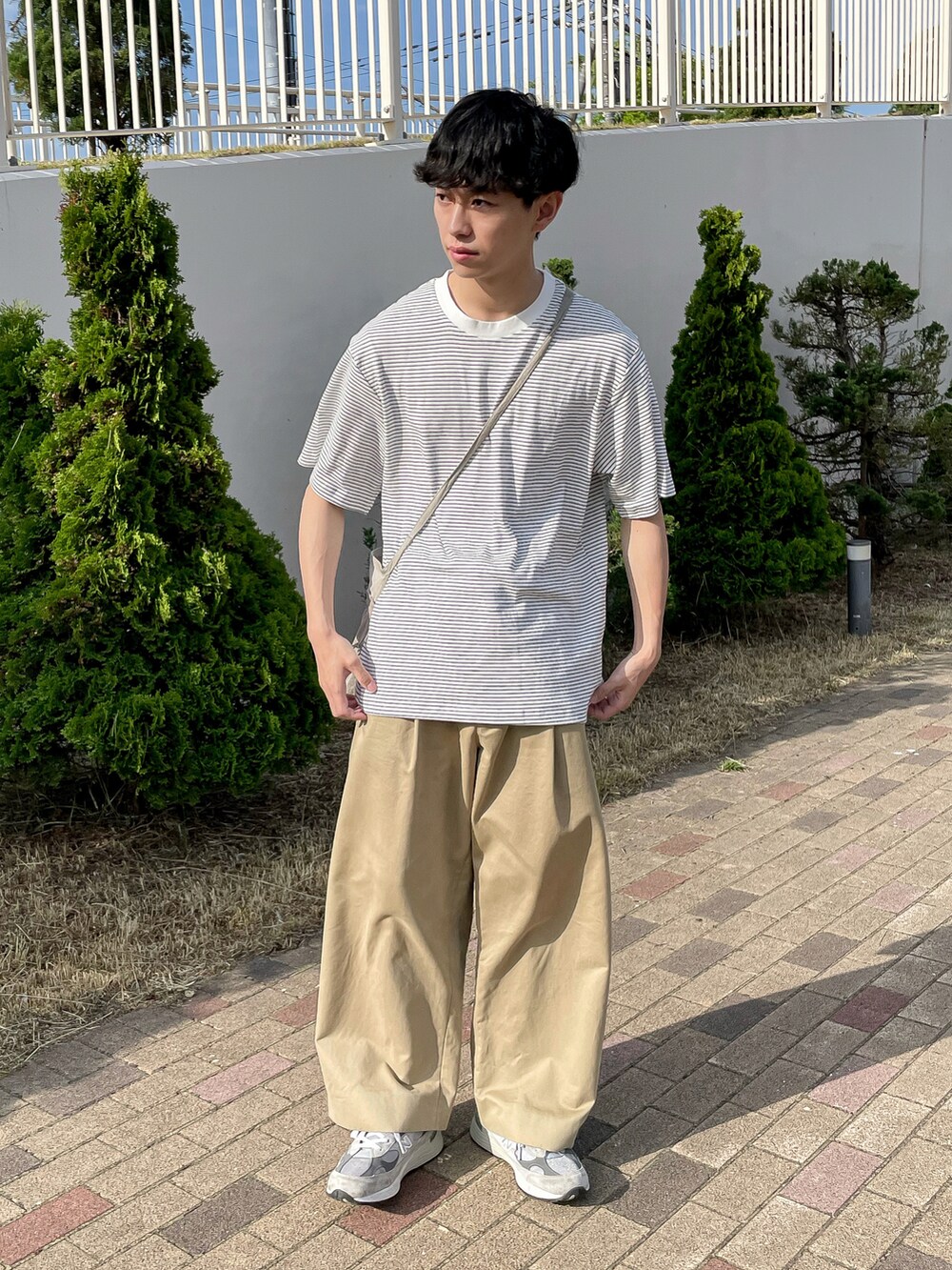 ホワイト系のトップス、ベージュ系のその他パンツ、グレー系のスニーカーを着用したメンズの夏コーディネートの2枚目の写真