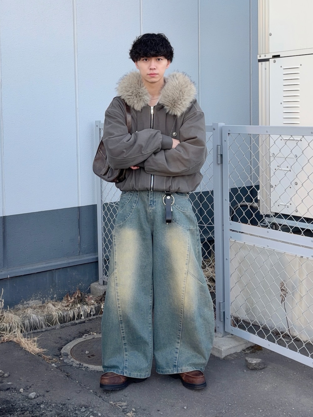 ブラウン系のブルゾン、ブルー系のデニムパンツ、ブラウン系のブーツを着用したメンズの冬コーディネートの2枚目の写真