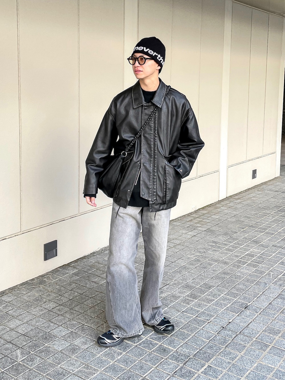 ブラック系のブルゾン、グレー系のニット/セーター、グレー系のデニムパンツを着用したメンズの冬コーディネートの3枚目の写真