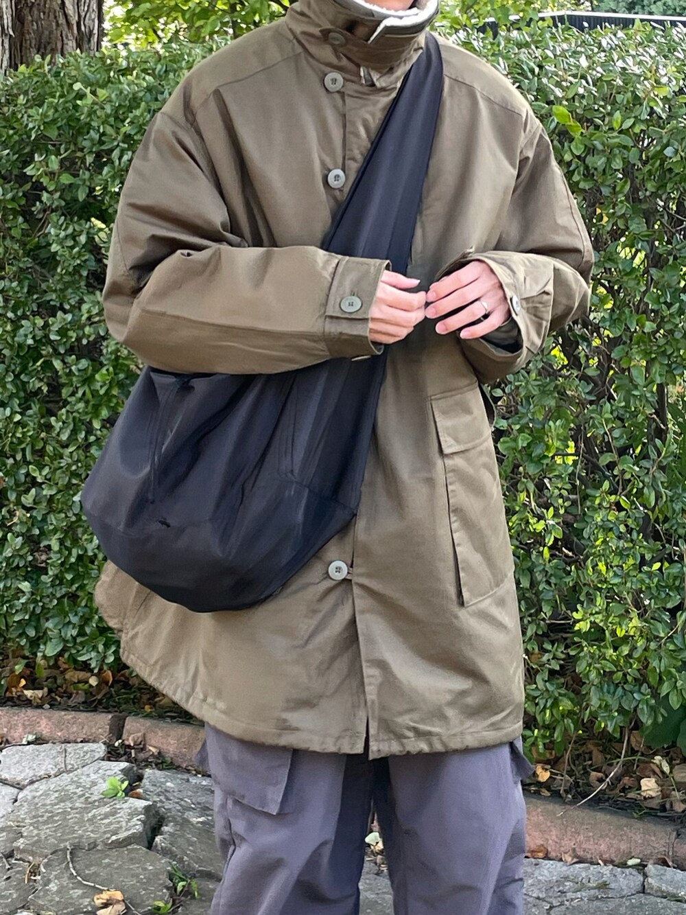 グリーン系のモッズコート、グレー系のカーゴパンツを着用したメンズの秋コーディネートの5枚目の写真