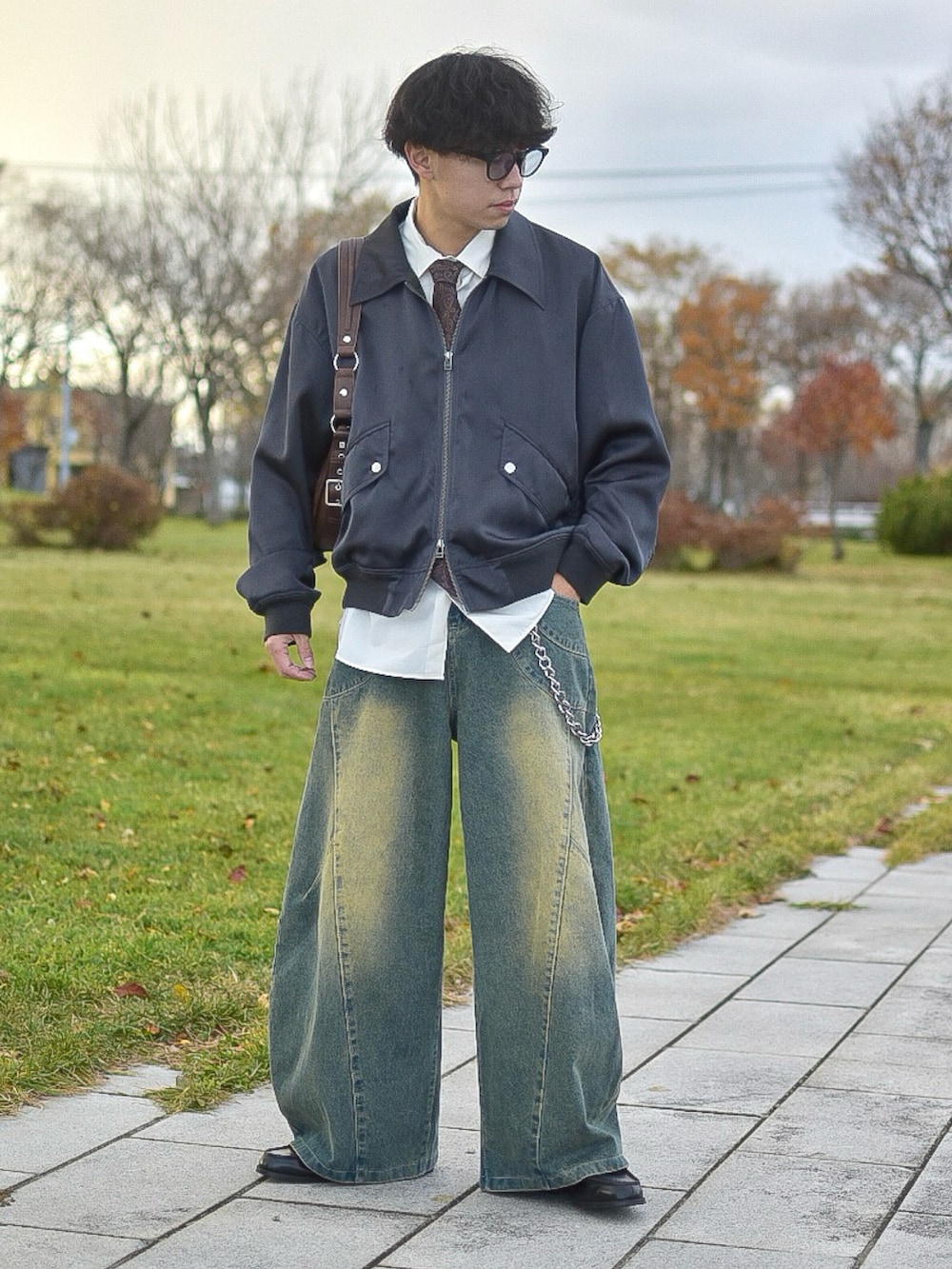 ブルー系のデニムパンツ、ブラウン系のネクタイ、ホワイト系のシャツ/ブラウスを着用したメンズの秋コーディネートの2枚目の写真