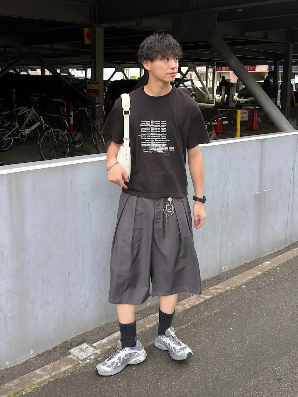 ブラック系のTシャツ/カットソー、グレー系のスラックス、グレー系のスニーカーを着用したメンズの夏コーディネートの3枚目の写真