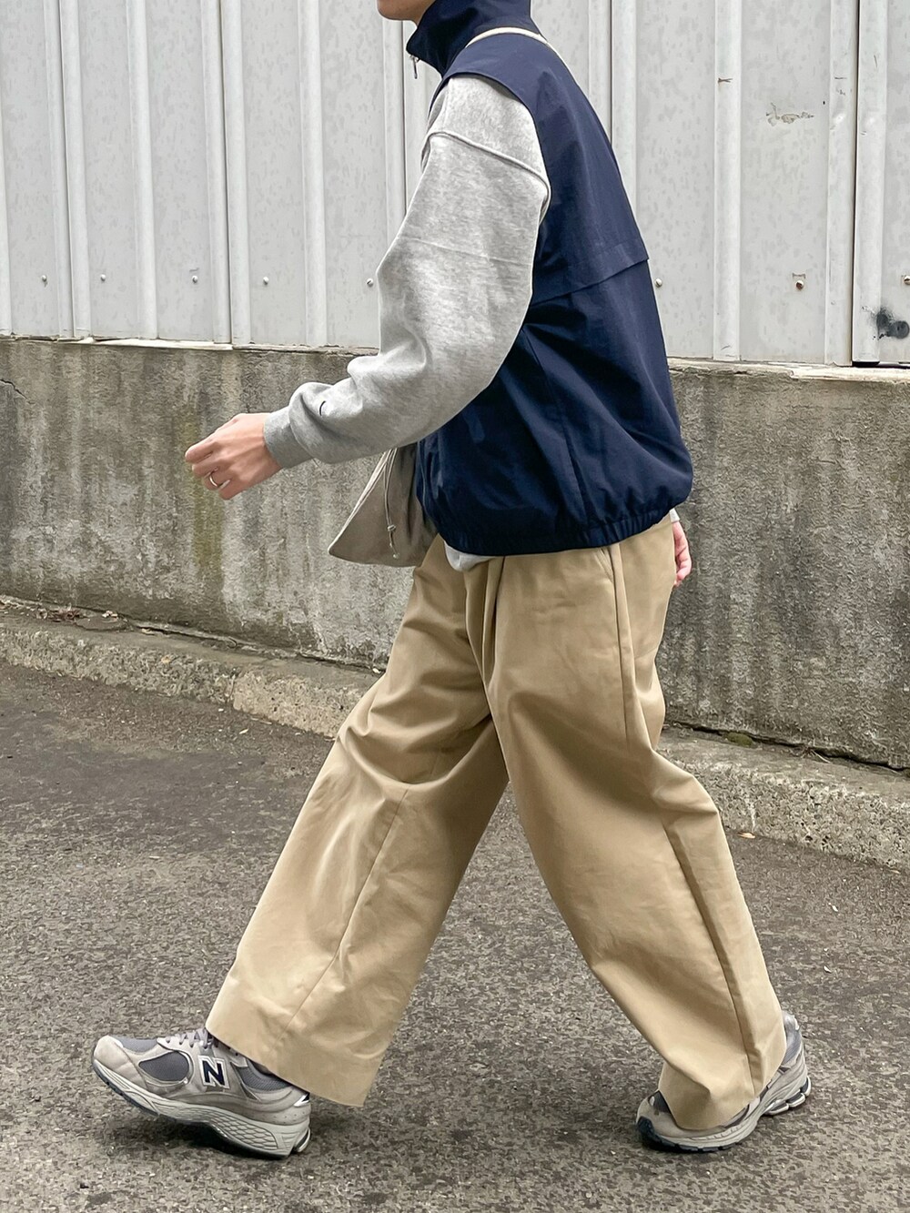 ブルー系のベスト、ベージュ系のその他パンツ、グレー系のスニーカーを着用したメンズの春コーディネートの5枚目の写真
