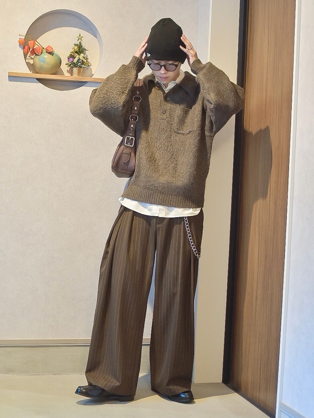 ブラウン系のポロシャツ、ホワイト系のシャツ/ブラウス、ブラウン系のスラックスを着用したメンズの秋コーディネートの2枚目の写真