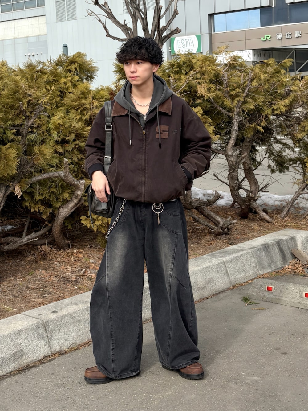 ブラック系のブルゾン、ブラック系のデニムパンツ、ブラウン系のブーツを着用したメンズの春コーディネートの4枚目の写真