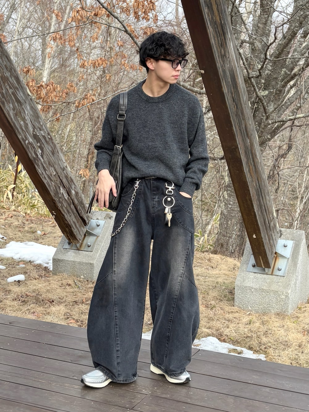 シルバー系のスニーカー、ブラック系のデニムパンツ、ブラウン系のニット/セーターを着用したメンズの冬コーディネートの4枚目の写真