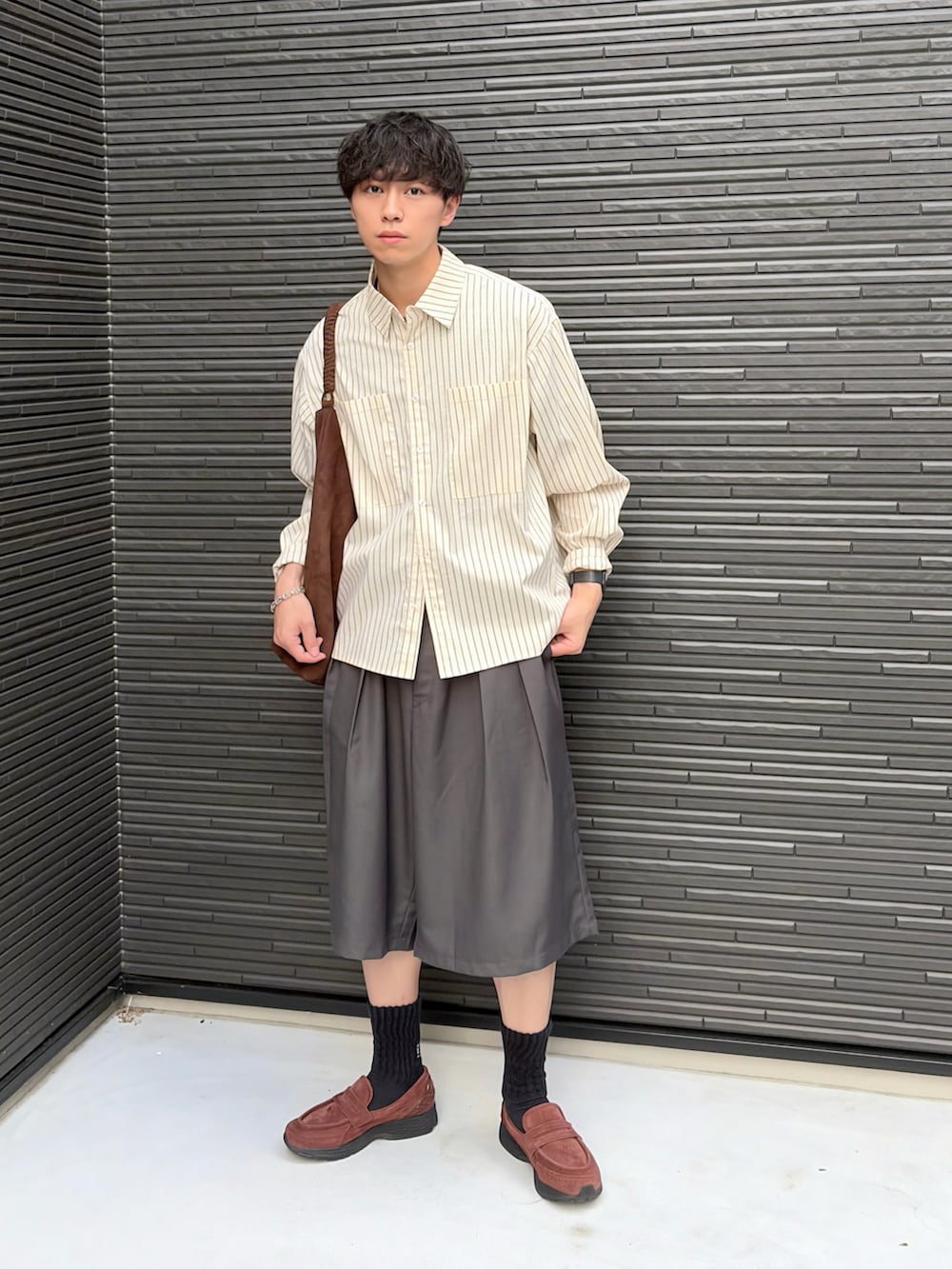 ブラウン系のトートバッグ、グレー系のスラックス、イエロー系のシャツ/ブラウスを着用したメンズの夏コーディネートの2枚目の写真