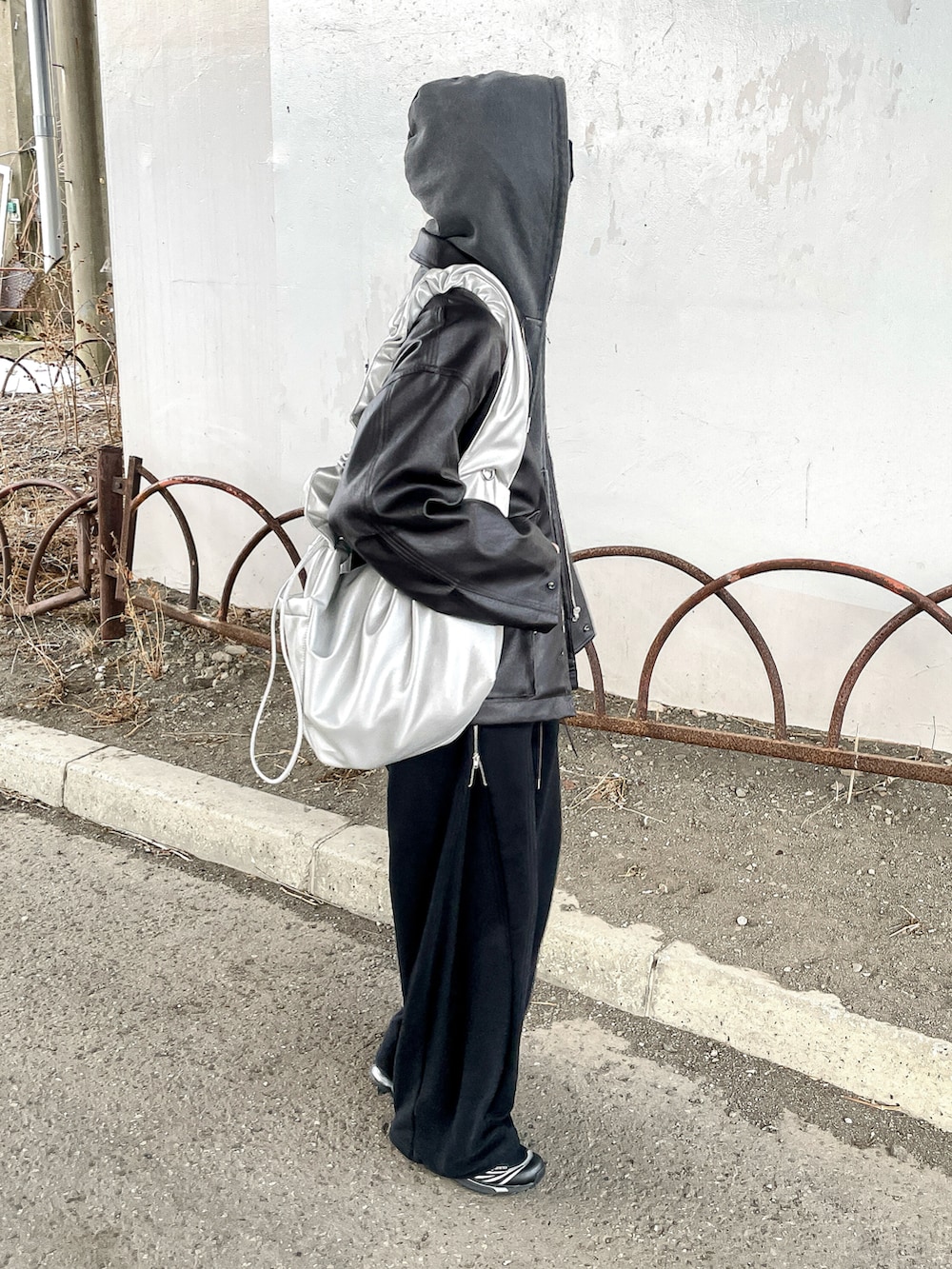 グレー系のパーカー、ブラウン系のブルゾン、ブラック系のスウェットパンツを着用したメンズの冬コーディネートの3枚目の写真