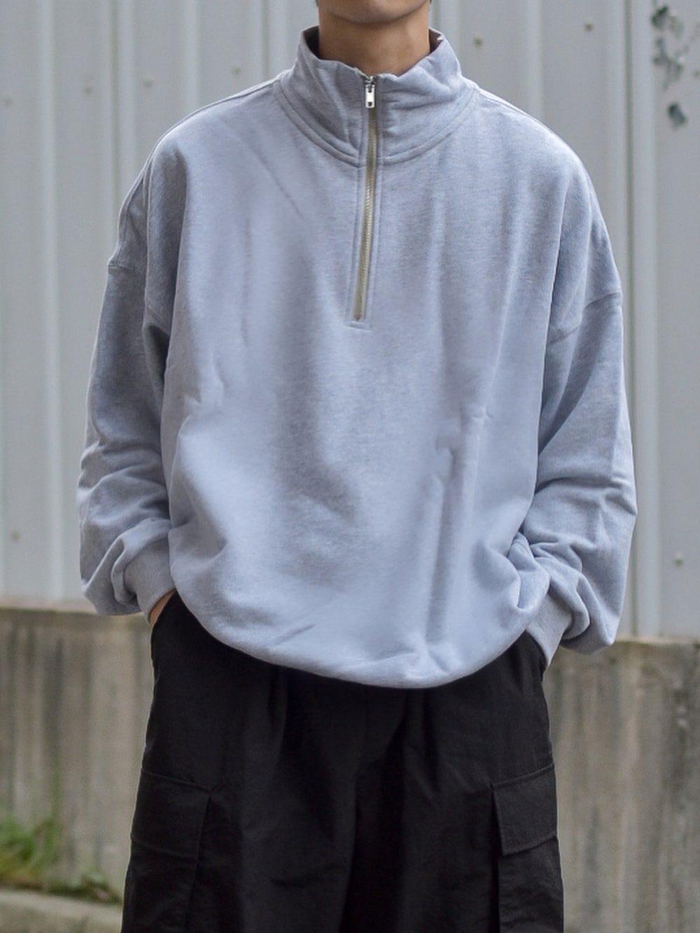 ブラック系のダウンベスト、グレー系のスウェット、ブルー系のショルダーバッグを着用したメンズの秋コーディネートの5枚目の写真