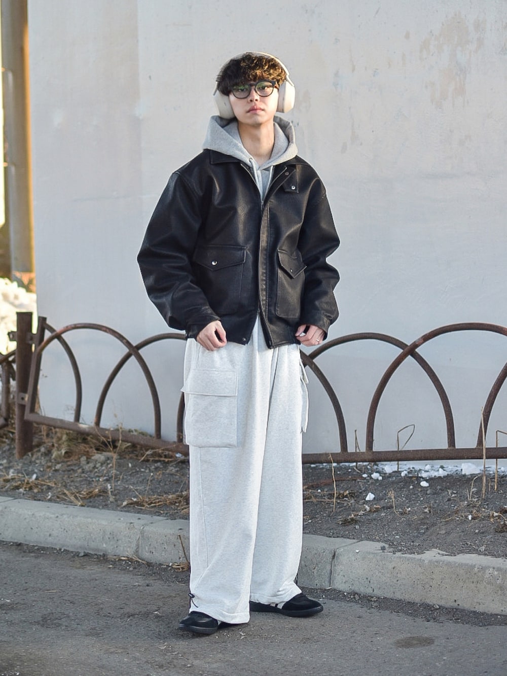 ブラック系のブルゾン、ブラック系のスニーカー、グレー系のパーカーを着用したメンズの冬コーディネートの5枚目の写真