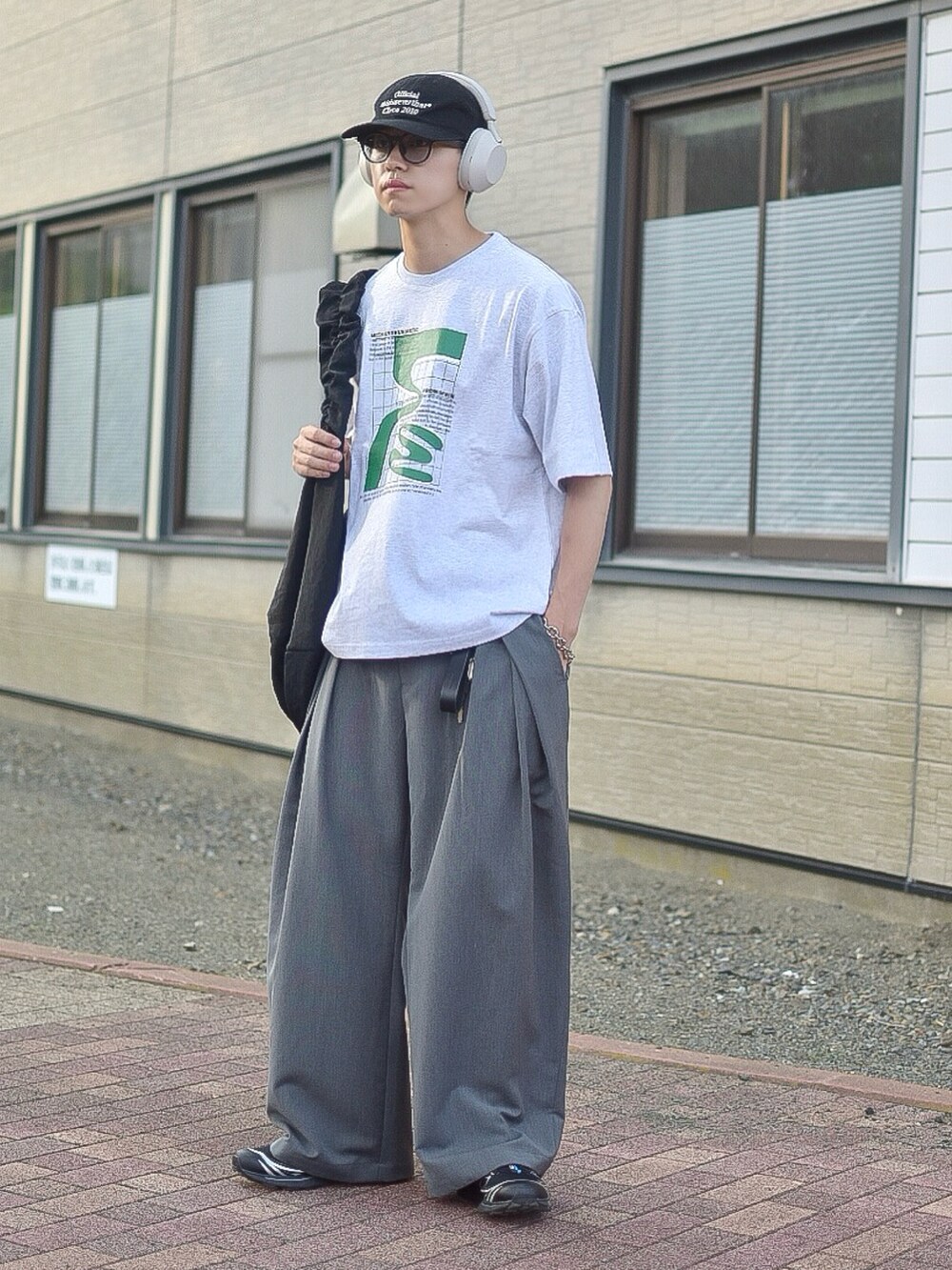 グレー系のTシャツ/カットソー、グレー系のスラックス、ブラック系のスニーカーを着用したメンズの夏コーディネートの3枚目の写真