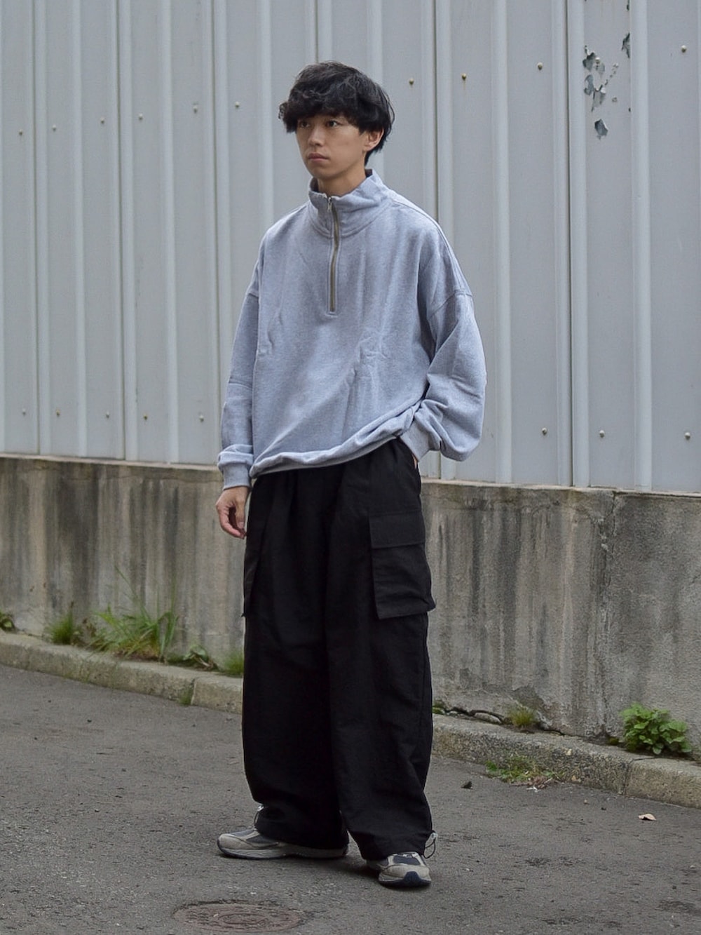 ブラック系のダウンベスト、グレー系のスウェット、ブルー系のショルダーバッグを着用したメンズの秋コーディネートの4枚目の写真